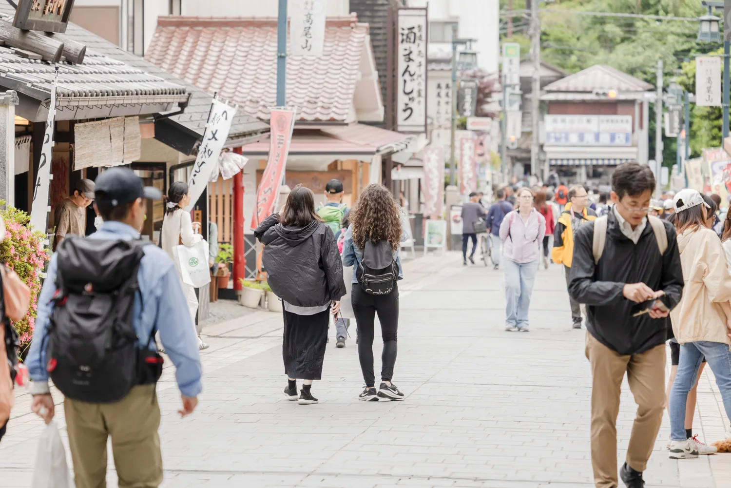 高尾山近くの商店街を歩く人々